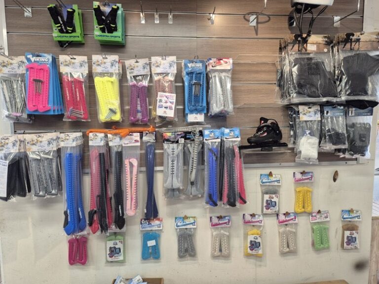 Wand in de winkel met schaatsbeschermers, veters en handschoenen